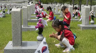 Murid-murid taman kanak-kanak berdoa di depan nisan tentara yang gugur selama Perang Korea 1950-1953 pada malam Memorial Day Korea Selatan di Pemakaman Nasional, Seoul, Korea Selatan, Senin (5/6/2023). Memorial Day di Korea Selatan diperingati setiap tanggal 6 Juni tiap tahunnya. (AP Photo/Ahn Young-joon)