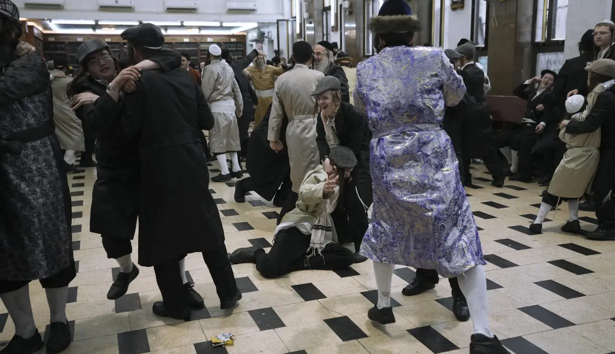Tarian ultra-Ortodoks Yahudi selama festival Yahudi Purim di Yerusalem, Jumat (18/3/2022). Hari libur Yahudi Purim memperingati keselamatan orang-orang Yahudi dari genosida di Persia kuno, seperti yang diceritakan dalam Kitab Ester. (AP Photo/Mahmoud Illean)