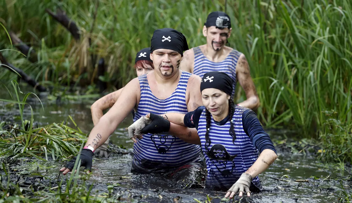 Sejumlah peserta bejalan dalam kubangan lumpur saat mengikuti kompetisi lari ekstrim di Zhodino, Minsk timur, Belarus, 26 September 2015. (REUTERS/Vasily Fedosenko)