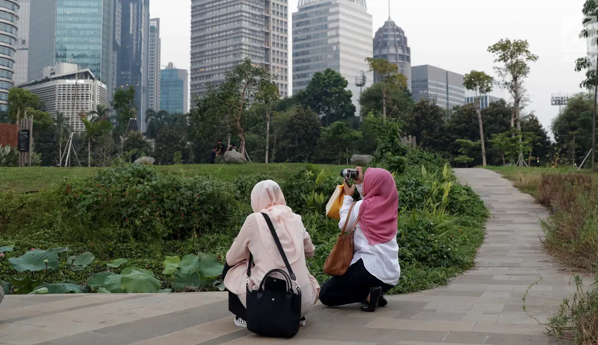 Warga menyalurkan hobi fotografi di area Hutan Kota Gelora Bung Karno, Jakarta, Kamis (20/6/2019). Sore hari banyak warga memanfaat waktu luang dengan berolahraga dan menyalurkan hobi fotografi di area Hutan Kota Gelora Bung Karno. (Liputan6.com/Helmi Fithriansyah)