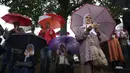 Pria dan wanita berdoa di sebelah truk yang membawa 50 peti mati berisi sisa-sisa korban genosida Srebrenica 1995 di Visoko, Bosnia, 8 Juli 2022. Sebanyak 50 jenazah korban genosida Srebrenica yang baru diidentifikasi akan diangkut ke Memorial Center di Potocari di mana mereka akan dimakamkan pada 11 Juli. (AP Photo/Armin Durgut)