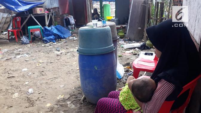 Seorang warga menggendong bayinya dengan tatapan kosong ke bekas bangunan rumahnya. Kebingungan mencari tempat berlindung untuk sang bayi. (foto: Liputan6.com / felek wahyu)