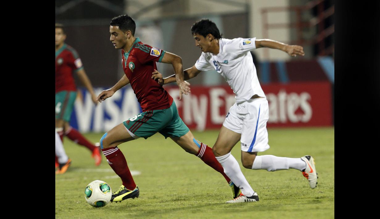 Pemain Timnas Maroko U-17, Sofyan Amrabat (kiri), mengontrol bola dibayangi pemain Uzbekistan U-17, Khumoyun Agzamov, dalam pertandingan Piala Dunia U-17 2013 yang berlangsung di Uni Emirat Arab, Senin (21/10/2013). Sofyan Amrabat bersama Timnas Maroko U-17 berhasil memuncaki Grup C Piala Dunia U-17 2013. (AFP/Karim Sahib)