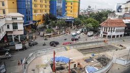 Kendaraan melintas dekat lokasi ditemukannya rel trem di lokasi proyek MRT Jakarta fase 2, Glodok, Jakarta, Selasa (28/12/2021). Rel trem itu ditemukan di bawah jalur TransJakarta di Jalan Pintu Besar Selatan pada Desember 2021. (Liputan6.com/Faizal Fanani)