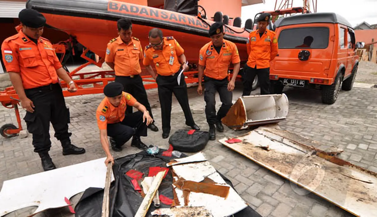 Petugas Basarnas Palu memperlihatkan sejumlah serpihan yang diduga milik Pesawat AirAsia di halaman kantor Basarnas, Sulawesi Tengah, Rabu (4/2/2015). (Liputan6.com/Dio Pratama)