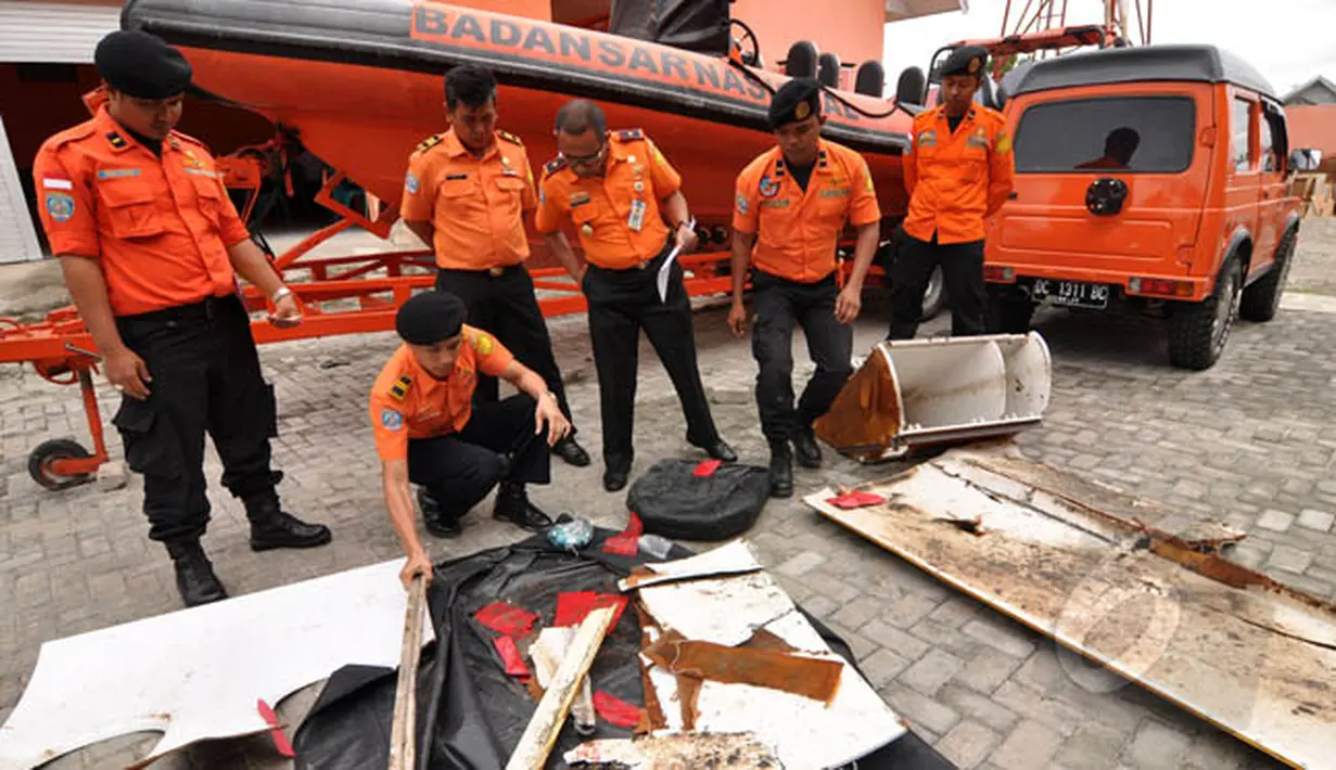 Petugas Basarnas Palu memperlihatkan sejumlah serpihan yang diduga milik Pesawat AirAsia di halaman kantor Basarnas, Sulawesi Tengah, Rabu (4/2/2015). (Liputan6.com/Dio Pratama)