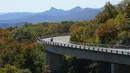 Seorang pengendara sepeda motor mengemudi di Linn Cove Viaduct, Grandfather Mountain di sepanjang Blue Ridge Parkway dekat Linville, North California, pada 18 Oktober 2021, ketika warna musim gugur mulai muncul. (AP Photo/Gerry Broome)