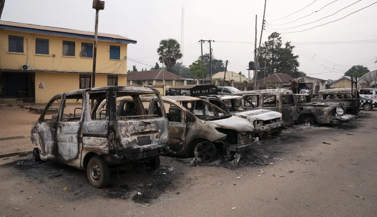Kendaraan yang terbakar diparkir di luar markas komando polisi di Owerri, Nigeria, Senin (5/4/2021). Lebih dari 1.800 narapidana melarikan diri setelah sekelompok orang bersenjata menyerang sebuah penjara di kota tenggara Nigeria menggunakan peledak. (AP Photo/David Dosunmu)