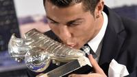 Bintang Real Madrid Cristiano Ronaldo mencium sepatu perak saat acara seremoni penghaargaan atas pencapain sebagai Top Skor sepanjang masa El Real di Stdion Santiago Bernabeu, Madrid, Jumat (2/10/2015).  AFP Photo / Gerard Julien