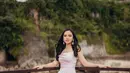 Gaun pink pudar tanpa lengan ini memanjang hingga menutupi kaki Lyodra Ginting. Keanggunannya menguat berkat rambut hitam yang dibiarkan tergerai plus anting. Ia bersandar di pagar berlatar bukit karang berhias pepohonan yang membaur dengan bibir laut. “Ngerti kan kenapa butuh sandaran,” tulis Lyodra Ginting bersama foto yang diunggah pada 8 Juli 2022. (Foto: Dok. Instagram @lyodraofficial)