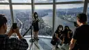 Pengunjung berpose untuk foto di bagian lantai kaca gedung pencakar langit Lotte World Tower 123 lantai di Seoul pada 22 September 2021. Bangunan tertinggi di Korea Selatan tersebut berlokasi di pinggiran Sungai Han, ibu kota Seoul. (Anthony WALLACE / AFP)