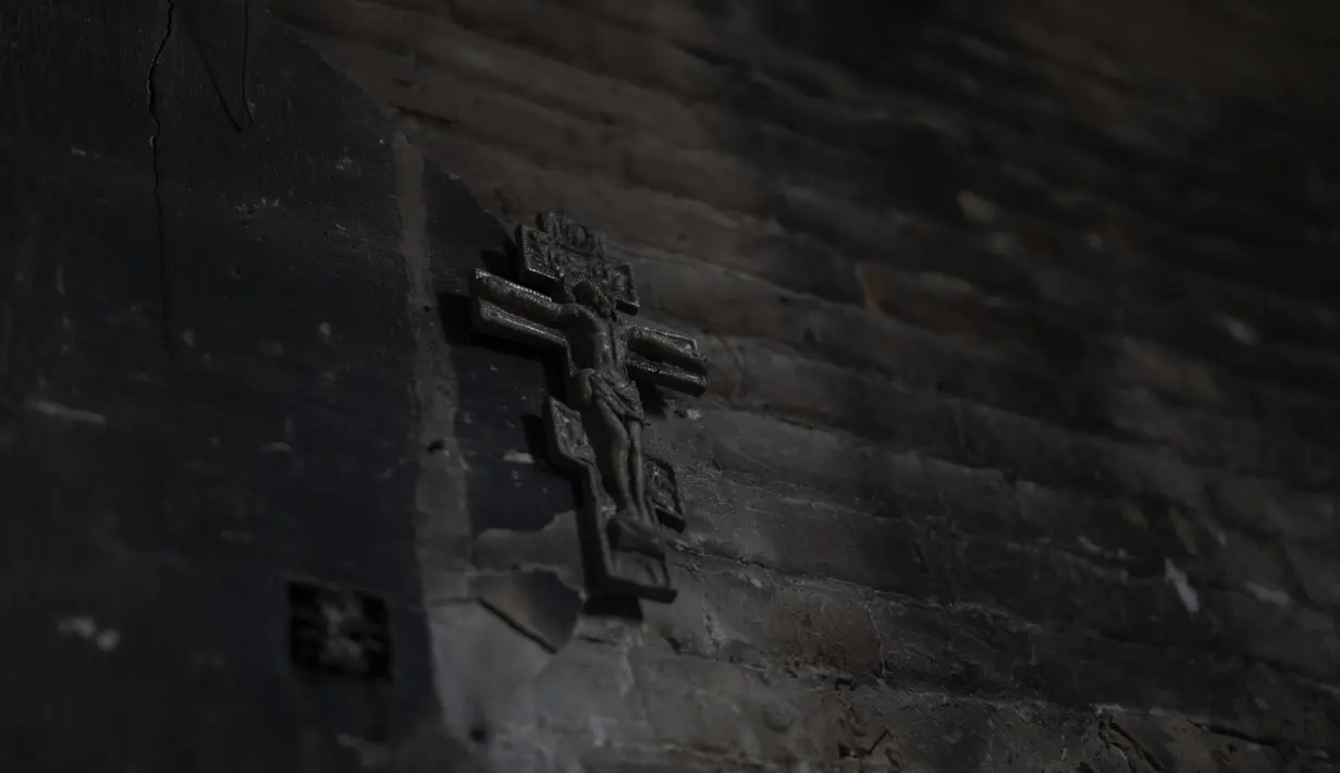 <p>Sebuah salib logam di dalam gereja di Lukashivka, dekat kota Chernihiv di Ukraina utara, 22 April 2022. Penduduk mengatakan tentara Rusia menggunakan rumah ibadah untuk menyimpan amunisi, dan pasukan Ukraina menembaki gedung itu untuk membuat Rusia pergi. (AP Photo/Petros Giannakouris)</p>
