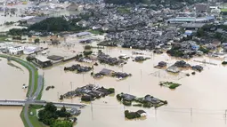 Banjir merendam rumah-rumah di Takeo, Prefektur Saga, Jepang, Rabu (28/8/2019). Otoritas Jepang memerintahkan evakuasi bagi 240 ribu warga di kawasan barat daya akibat hujan lebat selama beberapa hari belakangan. (Kyodo News via AP)