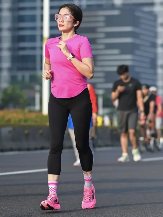 Tampil sporty, Ussy terlihat begitu fresh dengan busana bernuansa pink. Ia tampil dengan legging dan running attire bernuansa pink. [Foto: Instagram/ Ussy Sulistiawaty]