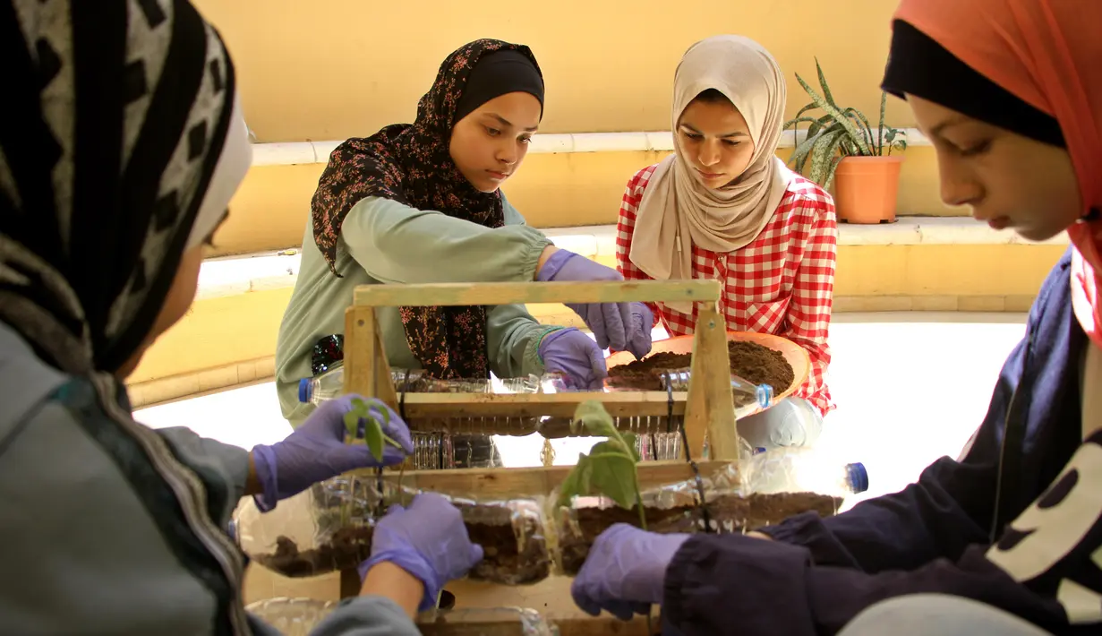 Anak-anak Palestina meletakkan tanaman ke dalam botol plastik di Pusat Anak-Anak Al-Qattan, Gaza City, Senin (20/7/2020). Anak-anak Palestina belajar bagaimana memanfaatkan kembali botol dan wadah plastik bekas untuk dekorasi taman. (Xinhua/Rizek Abdeljawad)