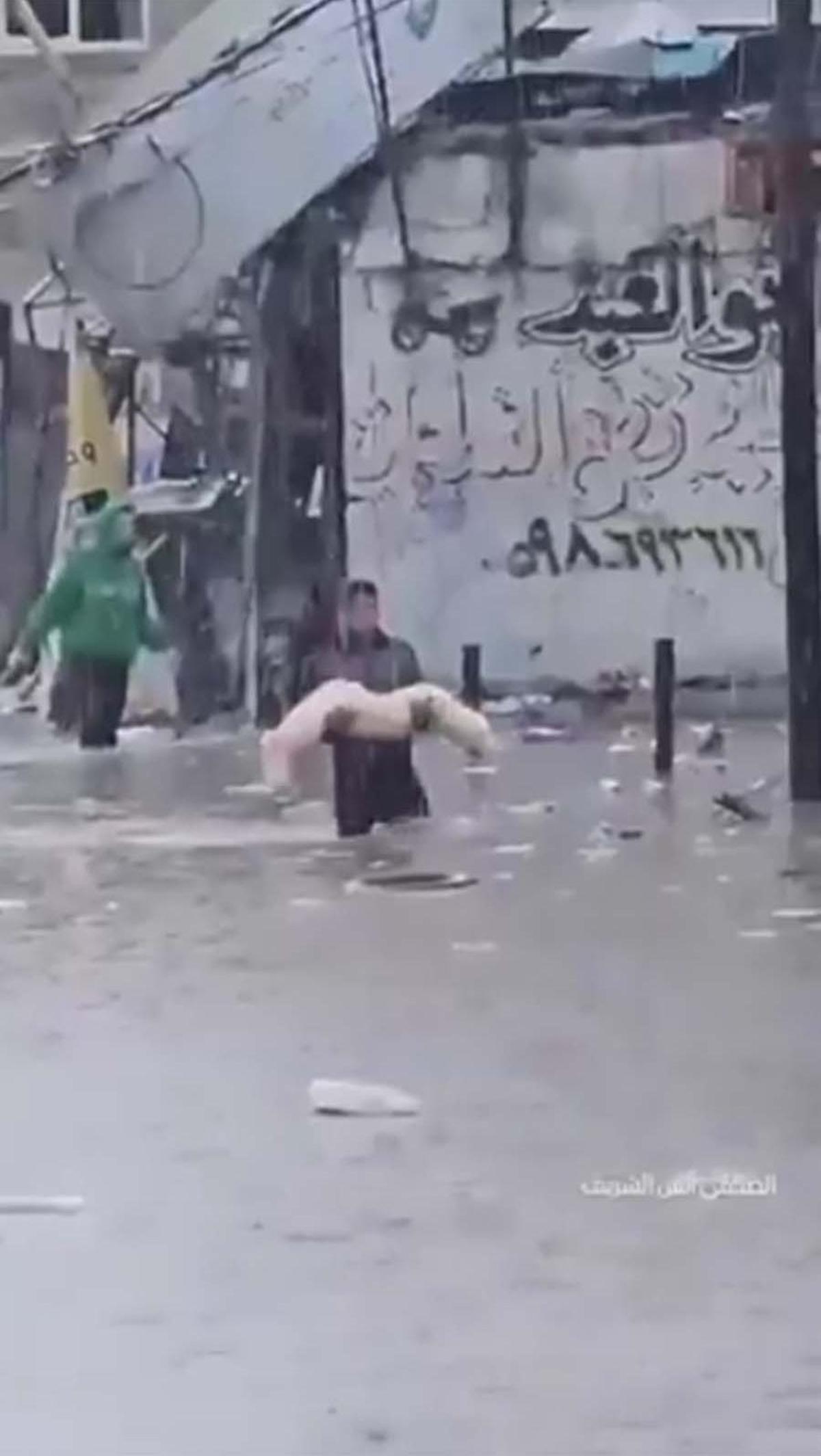 Video tersebut turut memperlihatkan sebuah pemandangan yang menyayat hati saat seorang pria Palestina menggendong jenazah yang terbungkus kain kafan putih di tengah banjir dan hujan deras.