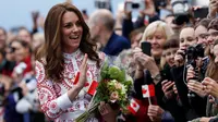 Duchess of Cambridge, Kate Middleton menyapa warga yang menyambutnya di Jack Poole Plaza, Kanada, Minggu (25/9). Kate Middleton tampil cantik dalam balutan busana di atas lutut bernuansa merah dan putih. (REUTERS/Chris Wattie)