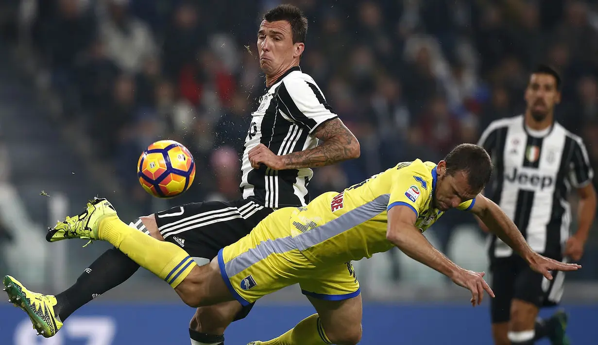 Striker Juventus, Mario Mandzukic, berebut bola dengan bek Pescara, Hugo Campagnaro. Gol pertama Si Nyonya Tua terjadi pada menit ke-36 melalui Semi Khedira. (AFP/Marco Bertorello)