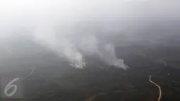Asap mengepul dari sejumlah titik api yang membakar hutan di wilayah Kaimantan Timur, Selasa (27/10). Kabut asap yang menyelimuti Kalimantan mulai berkurang dikarenakan beberapa wilayah sumber asap telah turun hujan. (Liputan6.com/Immanuel Antonius)