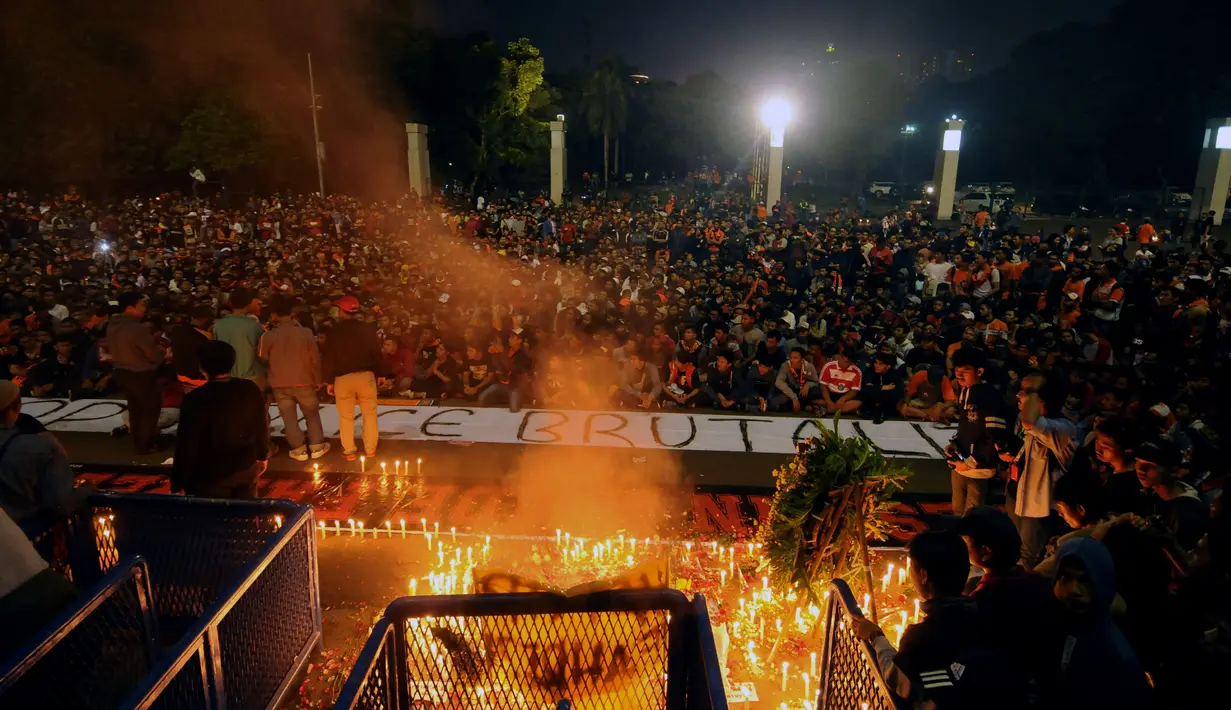 Suporter Persija duduk berdoa saat aksi di kawasan Stadion GBK Jakarta, Senin (16/5/2016). Aksi ini untuk mengenang wafatnya Fahreza saat akan menyaksikan laga Persija melawan Persela, Jumat pekan lalu. (Liputan6.com/Helmi Fithriansyah)