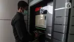 Pegawai memasukkan buku ke dalam mesin book drop di Perpustakaan Nasional, Jakarta. Kamis (18/3/2021). Perpustakaan Nasional menyediakan layanan pengembalian buku mandiri untuk pengunjung melalui mesin book drop. (Liputan6.com/Johan Tallo)
