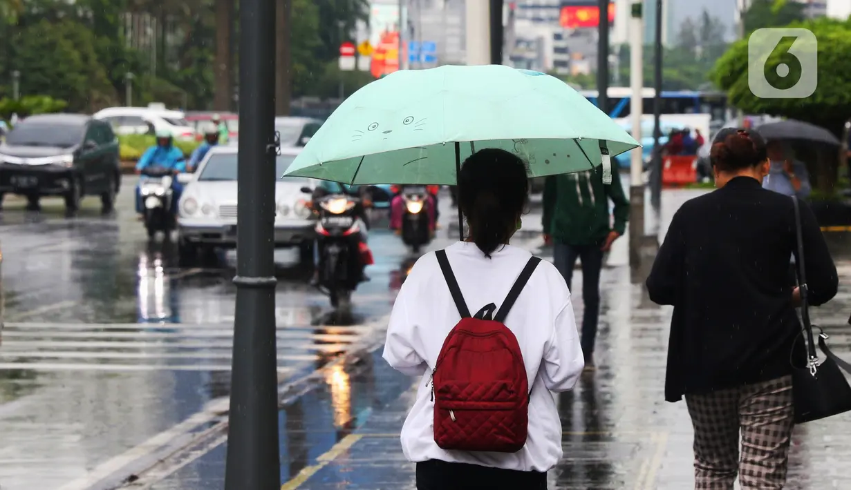 Warga menggunakan payung saat hujan mengguyur kawasan Jakarta, Senin (3/2/2020). Badan Meteorologi, Klimatologi, dan Geofisika (BMKG) merilis informasi peringatan dini cuaca ekstrem yang diperkirakan berlangsung hingga Rabu (5/2/2020) mendatang. (Liputan6.com/Angga Yuniar)