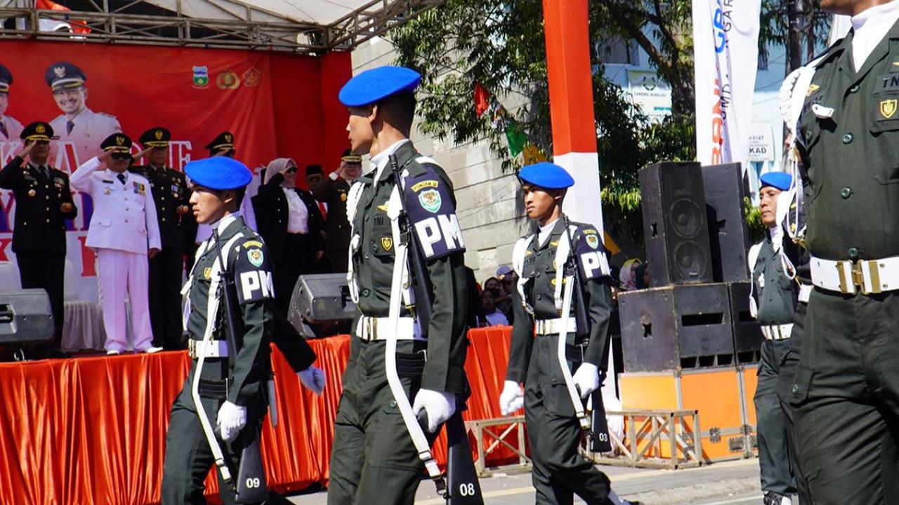 Sejumlah pejabat pemerintah, tokoh masyarakat, dan pelajar berkumpul untuk menghormati bendera Merah Putih yang berkibar dengan gagah.