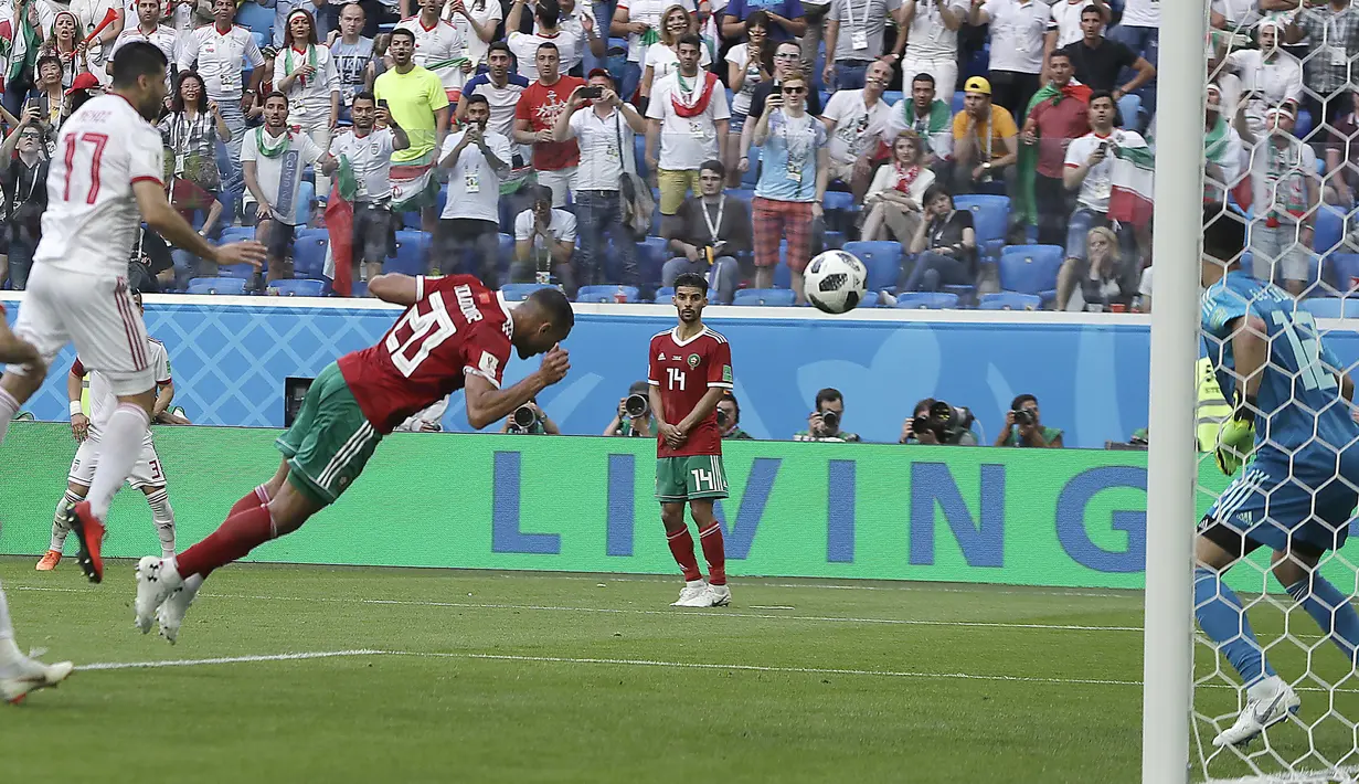 Pemain Moroko, Aziz Bouhaddouz (20) melakukan gol bunuh diri saat melawan Iran pada laga grup B Piala Dunia 2018 di St. Petersburg Stadium, Rusia, (15/6/2018). Iran menang 1-0. (AP/Themba Hadebe)