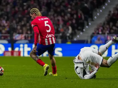 Pemain  Real Madrid, Brahim Diaz, terjatuh saat berebut bola dengan pemain Atletico Madrid, Rodrigo De Paul, dalam laga babak 16 besar Copa del Rey 2023/2024 yang digelar di Metropolitano, Jumat (19/1/2024). Los Rojiblancos  menang dengan skor 4-2. (AP Photo/Manu Fernandez)