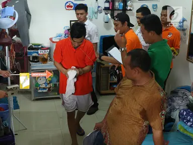 Tersangka pembunuhan wanita yang ditemukan tewas di dalam lemari memeragakan adegan peristiwa di Tempat Kejadian Perkara di kawasan Mampang, Jakarta, Jumat (23/11). 13 adegan dilakukan para tersangka dalam rekonstruksi. (Liputan6.com/Helmi Fithriansyah)