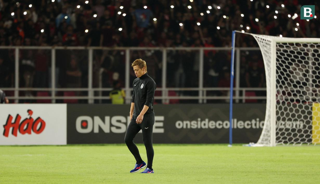 Manajer Timnas Kamboja, Keisuke Honda, tertunduk lesu setelah dikalahkan Indonesia pada laga Grup A Piala AFF 2022 di Stadion Utama Gelora Bung Karno (SUGBK), Senayan, Jumat (23/12/2022). (Bola.com/Abdul Aziz)