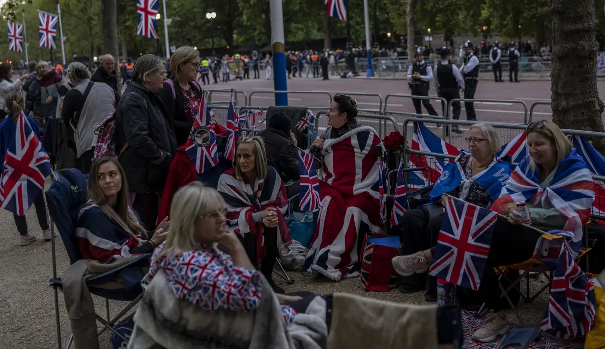 Orang-orang berkemah di depan Istana Westminster pada malam pemakaman Ratu Elizabeth II di London, Minggu, 18 September 2022. Pemakaman Ratu Elizabeth II, raja terlama di Inggris, berlangsung pada Senin (19/9). (AP Photo/Bernat Armangue)