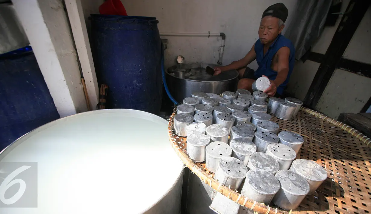 Pekerja mencuci cetakan  kue keranjang usai digunakan mencetak di industri kue keranjang rumahan Yogyakarta, (22/1). Kue keranjang disini dijual dengan harga Rp. 33.000 per kilogram. (Boy Harjanto)