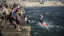 Warga melompat ke laut saat menikmati musim panas yang cerah di pantai Kota Gaza, Palestina, Jumat (3/7/2020). (AP Photo/Khalil Hamra)