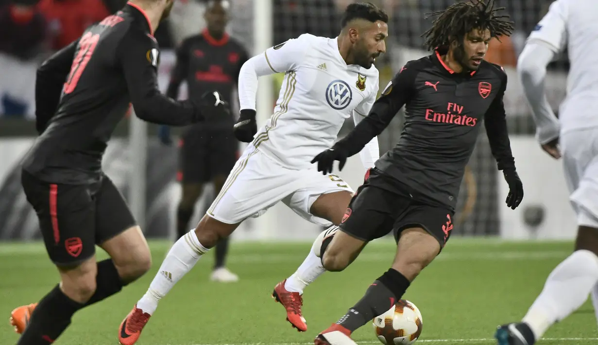 Pemain Ostersund, Saman Ghoddos (tengah) berebut bola dengan pemain Arsenal, Mohamed Elneny  pada babak 32 besar Liga Europa di Jamtkraft Arena, Ostersund, Swedia (15/2/2018). Arsenal menang 3-0. (Robert Henriksson/TT News Agency via AP)
