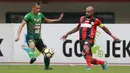 Pemain Persipura Jayapura, Ruben Sanadi (kiri) berebut bola dengan pemain PS TNI, Ahamd Noviandani pada lanjutan Liga 1 2017 di Stadion Patriot, Bekasi (4/11/2017). PS TNI menang 2-1. (Bola.com/Nick Hanoatubun)