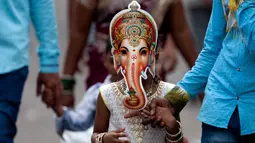 Gadis India mengenakan topeng Dewa Ganesha dalam rangka festival Ganesha Chaturthi di Hyderabad, India, Selasa (5/9). Dalam festival ini, seluruh umat hindu India memperingati hari lahir Dewa Ganesha. (Mahesh Kumar A/AP Photo)