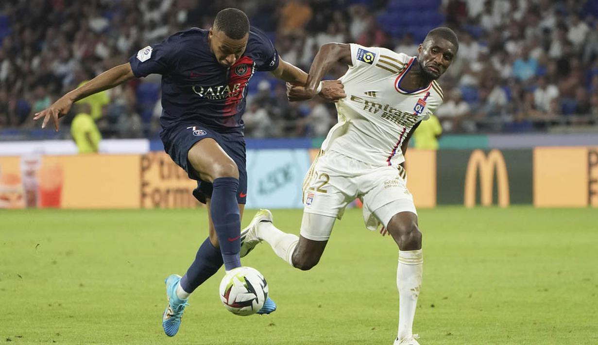 Pemain Paris Saint-Germain (PSG), Kylian Mbappe, berebut bola dengan pemain Lyon, Clinton Mata pada laga pekan keempat Ligue 1 2023/2024 di Groupama Stadium, Senin (04/09/2023). PSG menang dengan skor 4-1. (AP Photo/Laurent Cipriani)