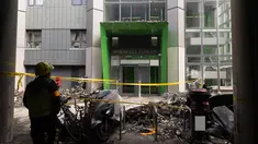 Petugas pemadam kebakaran berdiri di depan bangunan apartemen Grenfell Tower di London yang hangus terbakar, Minggu (18/6). Kebakaran dahsyat pada 14 Juni 2017 kemarin menghanguskan bangunan apartemen 24 lantai tersebut. (Metropolitan Police via AP)