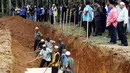 Warga membantu proses pemakaman massal jenazah yang di duga etnis Rohingya di Alor Setar, Malaysia, Senin (22/6/2015).  21 dari 106 jenazah tak dikenal yang ditemukan bulan lalu dimakamkan hari ini. (Reuters/Olivia Harris)