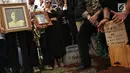 Sanak keluarga dan kerabat membawa potret gambar artis senior RMH Heroe Siswanto atau dikenal Sys NS saat pemakamannya di TPU Jeruk Purut, Jakarta, Selasa (23/1). (Liputan6.com/ Herman Zakharia)