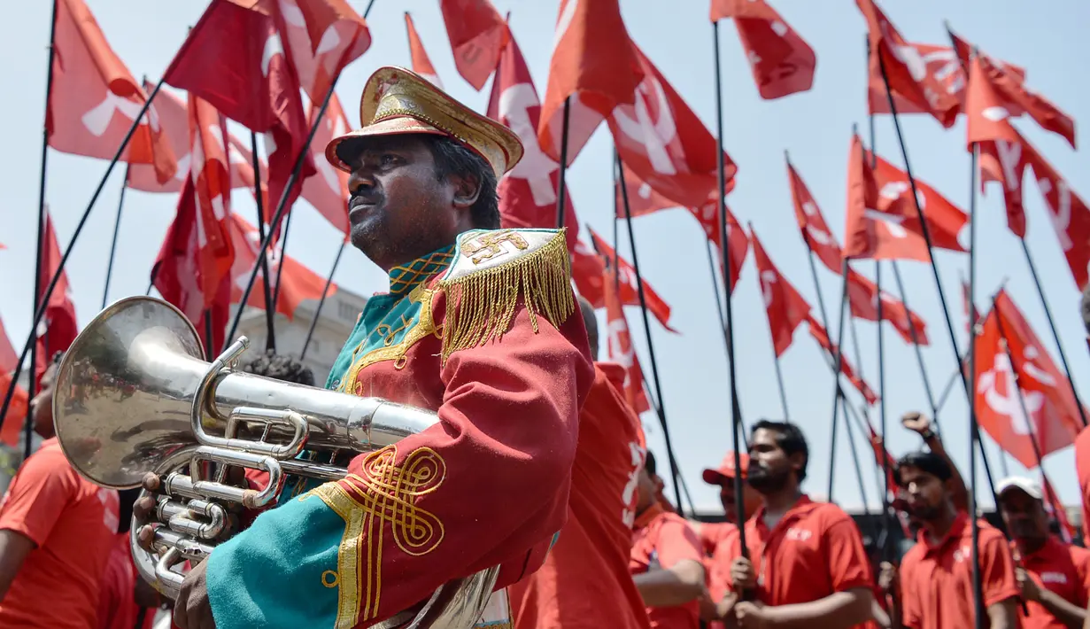 Pekerja India berpakaian merah selama pawai May Day di Bangalore, Senin (1/5). Pekerja di berbagai belahan dunia mengadakan aksi Hari Buruh Internasional dengan memadati jalan-jalan besar untuk menyuarakan aspirasi. (MANJUNATH KIRAN/A.M. Ahad)