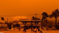 Warga setempat meninggalkan rumah mereka di Pulau Evia, Yunani di tengah kebakaran hutan hebat hari Minggu (8/8). (AP)