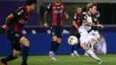 Gelandang Juventus, Federico Bernardeschi (kanan) berusaha menembak bola ke arah gawang Bologna pada pertandingan lanjutan liga Serie A Italia di stadion Renato-Dall'Ara di Bologna (22/6/2020). Juventus menang 2-0 atas Bologna. (Miguel MEDINA / AFP)