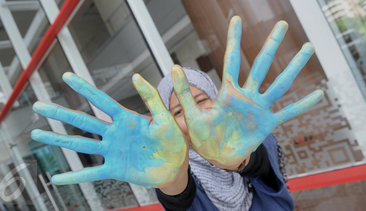 Seorang aktivis menempelkan tangannya pada cat dalam rangka acara peringatan anti korupsi 2015 LKPP, KPK, dan ICW bertajuk Hackathon Merdeka 3.0 di Jakarta, (05/12). (Liputan6.com/Faisal R Syam)