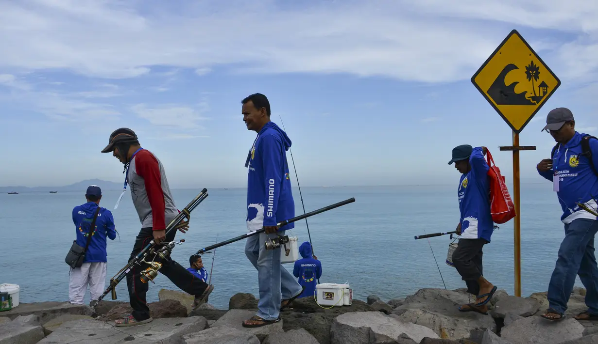 Peserta bersiap mengikuti kompetisi memancing di pantai Banda Aceh (24/11/2019). Para peserta ditempatkan di area sepanjang 2,5 kilometer, di sepanjang tanggul pesisir jalan yang menghubungi Gampong Jawa dan jembatan dekat Pelabuhan Ulee Lheue. (AFP Photo/Chaideer Mahyuddin)