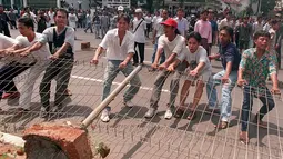 Para mahasiswa merusak pagar kampus mereka untuk bisa keluar dan menggelar unjuk rasa anti-pemerintah pada 14 Mei 1998. Bulan Mei 1998 merupakan momen penting dalam sejarah Indonesia, juga momen penting bagi Soeharto. (KEMAL JUFRI/AFP)