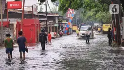 Aktivitas warga saat banjir merendam Jalan KH. Ahmad Dahlan Cipondoh, Tangerang, Selasa (16/2/2021). Hujan deras yang melanda wilayah Tangerang mengakibatkan ruas jalan alternatif penghubung Tangerang dengan Jakarta tersebut banjir setinggi lutut orang dewasa. (Liputan6.com/Angga Yuniar)