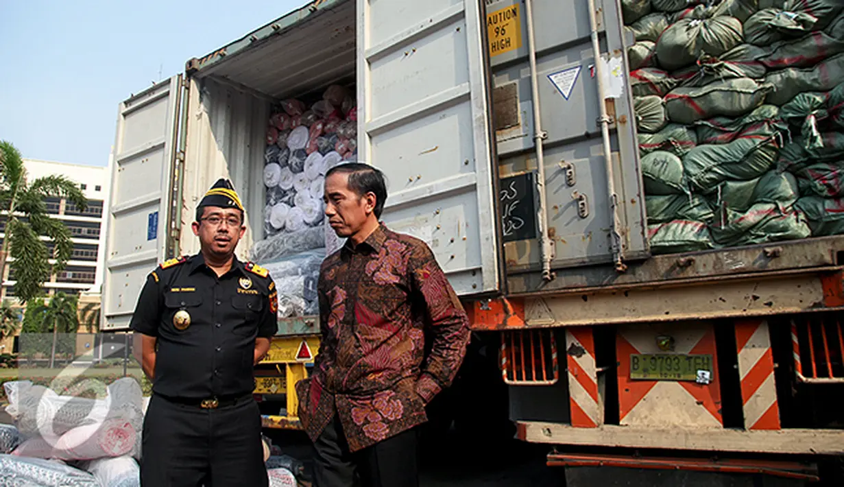 Presiden Joko Widodo berbincang dengan Dirjen Bea Cukai Heru Pambudi saat penindakan barang tekstil impor ilegal di Jakarta, Jumat (16/10/2015). Jokowi menyebut, maraknya impor tekstil ilegal merusak industri nasional. (Liputan6.com/Faizal Fanani)