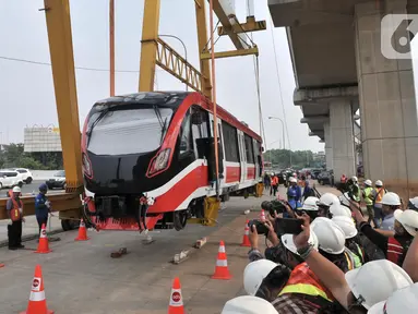 Proses perdana gerbong kereta layang ringan atau light rail transit (LRT) ke lintasan rel di Stasiun Harjamukti, Cibubur, Minggu (13/10/2019). Sebanyak satu rangkaian (trainset) yang terdiri dari 6 kereta (car) diangkat ke atas rel menggunakan Gantry Crane. (merdeka.com/Iqbal S Nugroho)